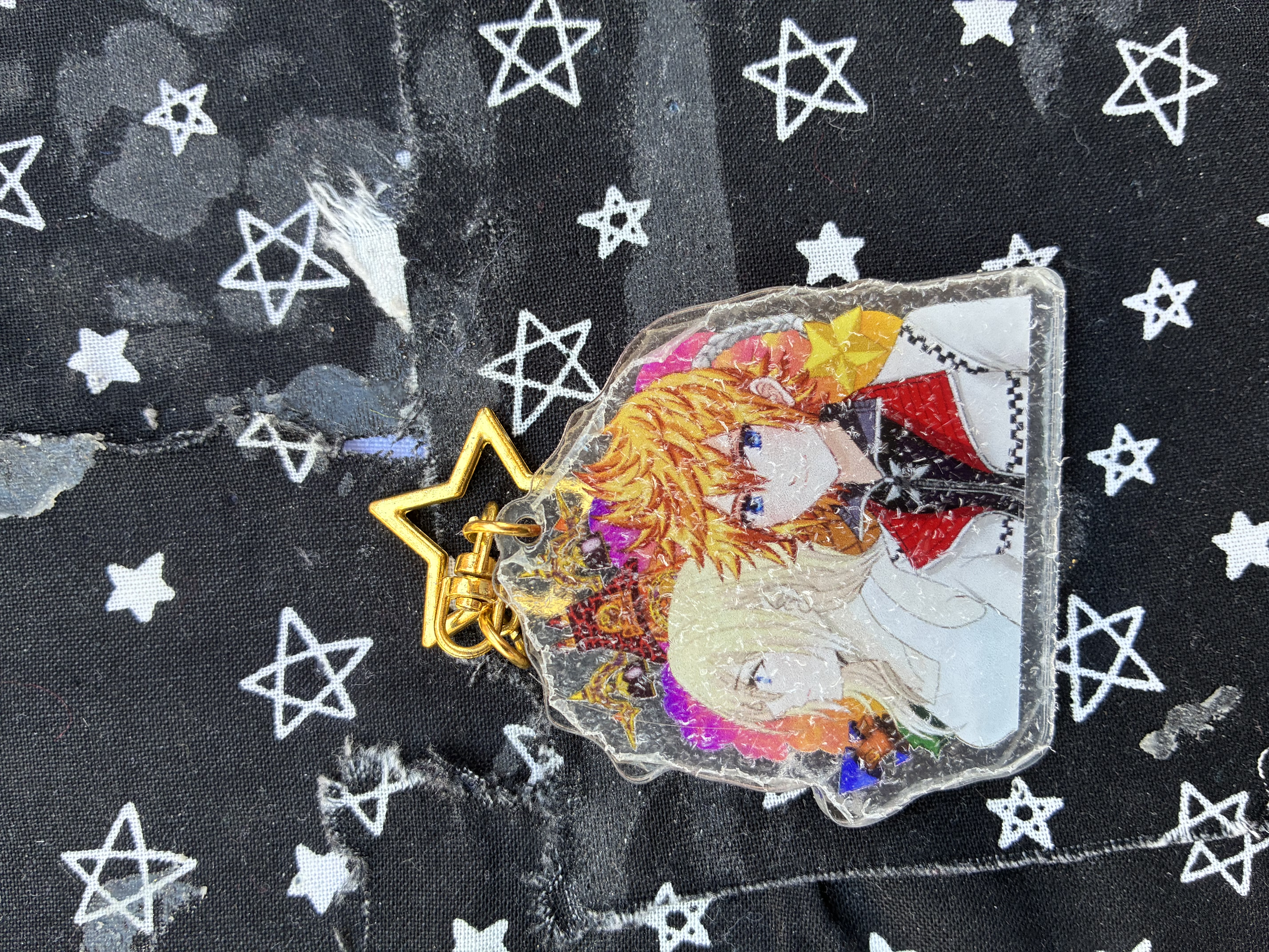 Acrylic charm of Kingdom hearts Roxas and Namine with twilight town landmarks in the background.
